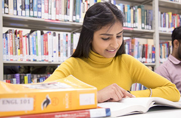 alexander college student studying inside the library about biology