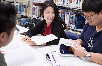 Alexander College students studying together inside the library