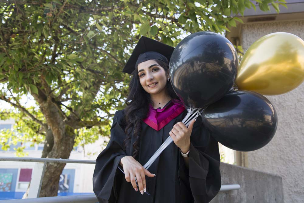 graduate posing with balloons
