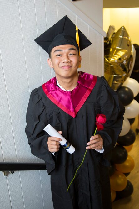 graduate student holding a flower and degree
