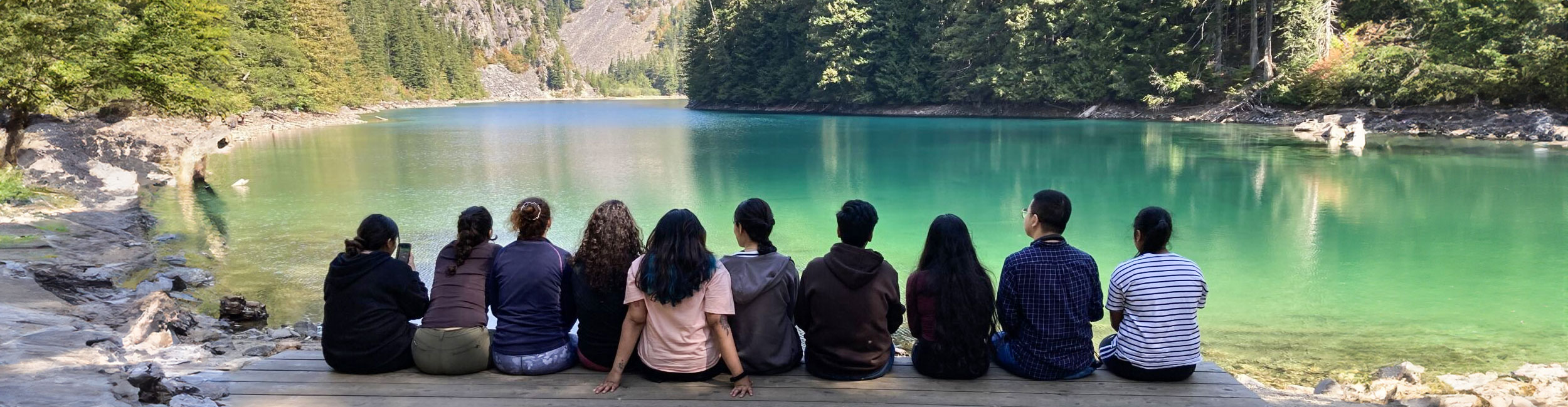 a group of students sitting at Lindeman Lake