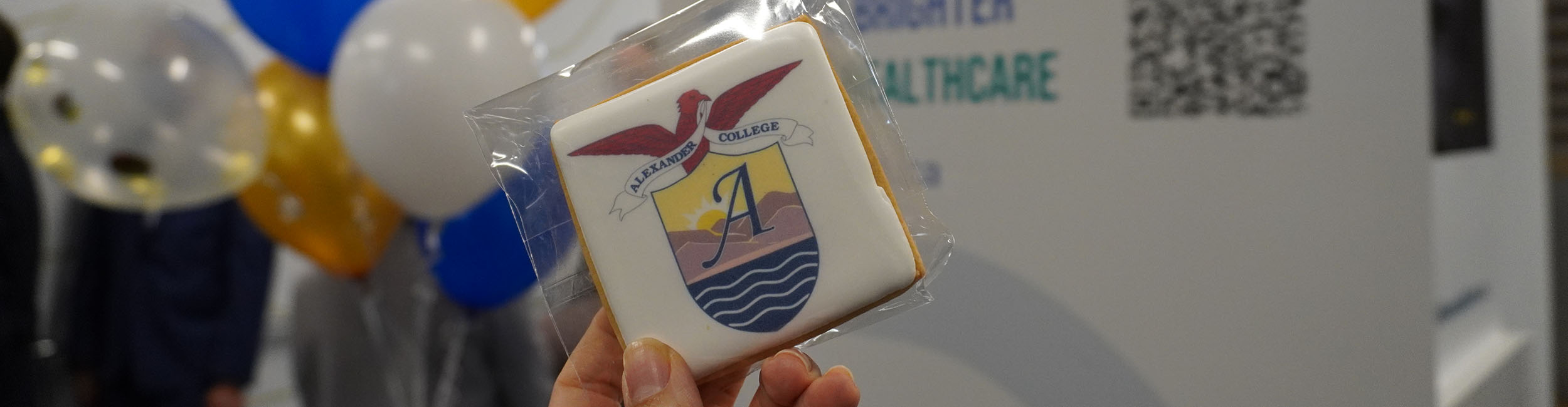 hand holding up an Alexander College cookie