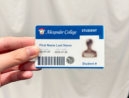 hand holding up an Alexander College Student ID card