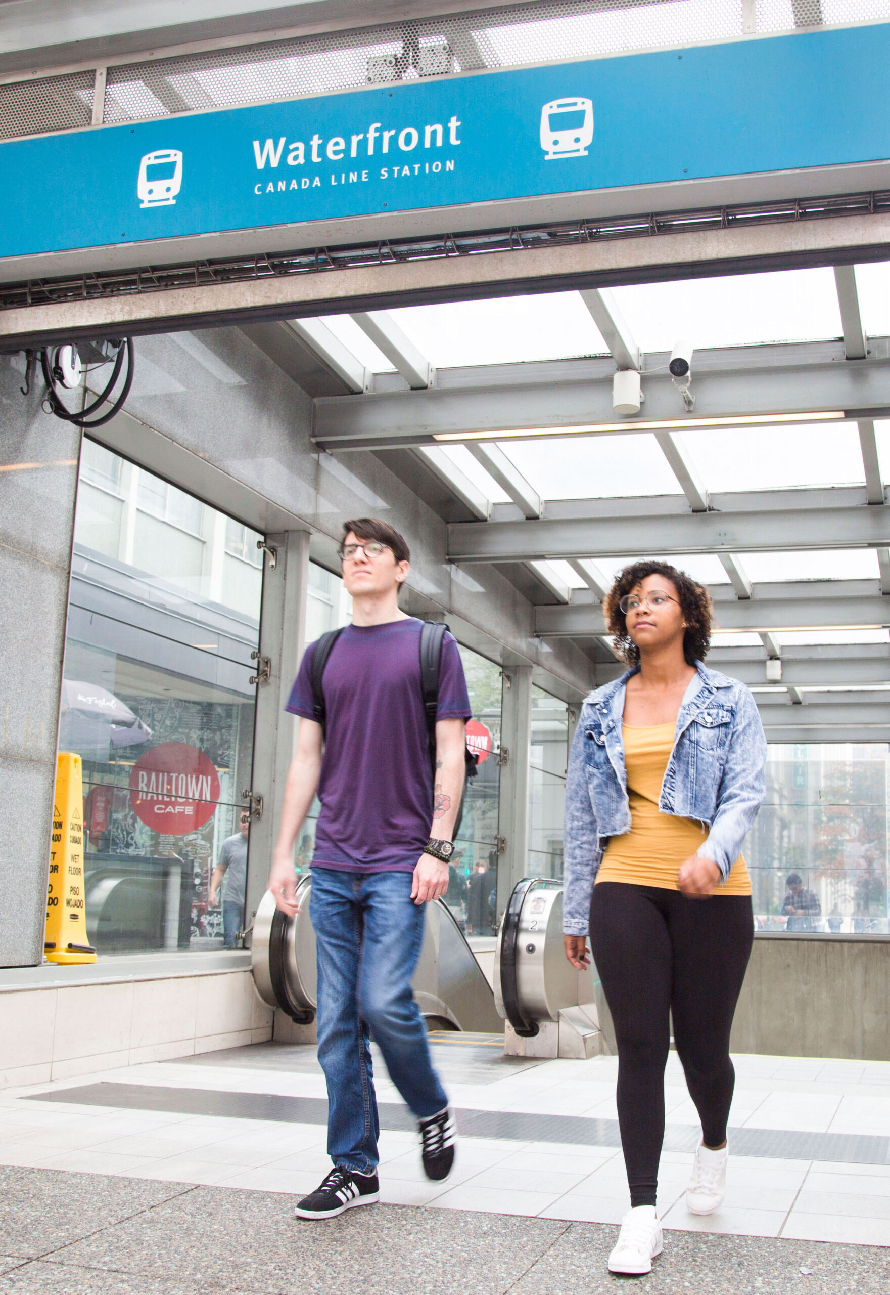 two students walking out of Waterfront Station on the Canada Line