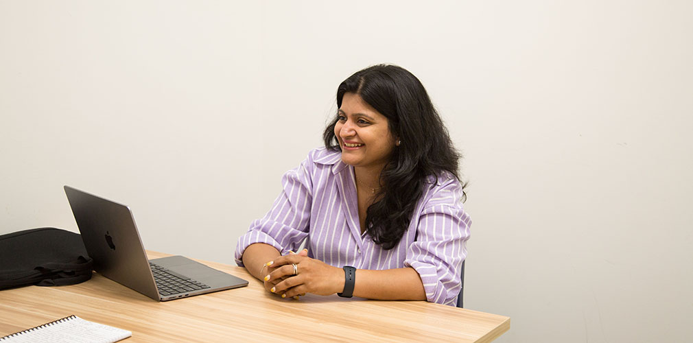 Swati smiling with a laptop