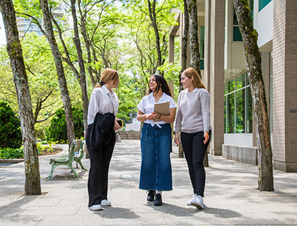 three students walking and talking outside