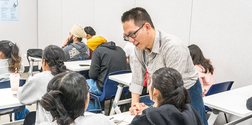 Angus helping students with a class activity