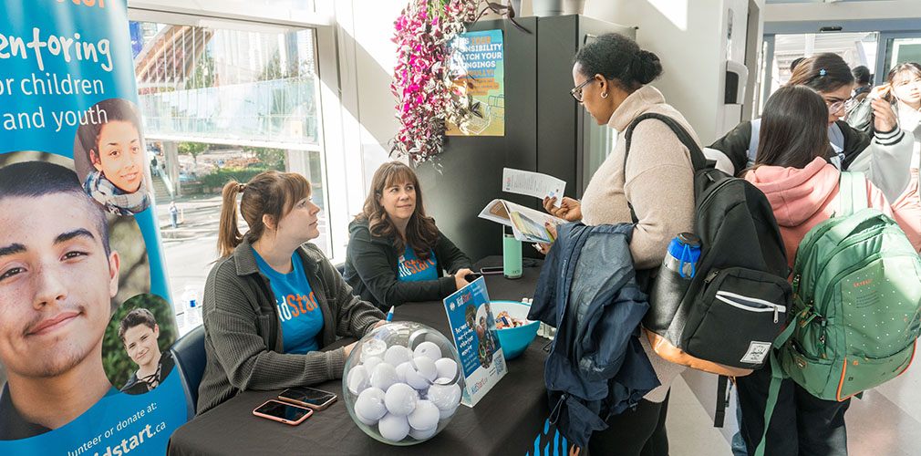 student talking to some volunteers