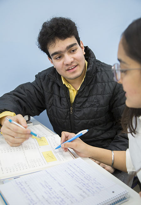 a student discussing notes with another student