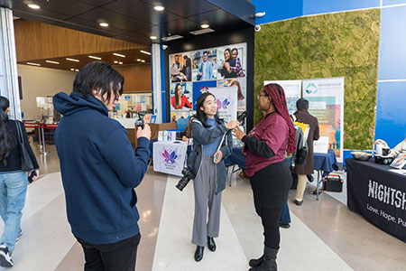 behind the scenes social media team interviewing a student