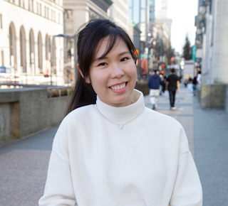 student smiling and standing outside