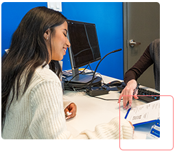 staff helping a student with a document